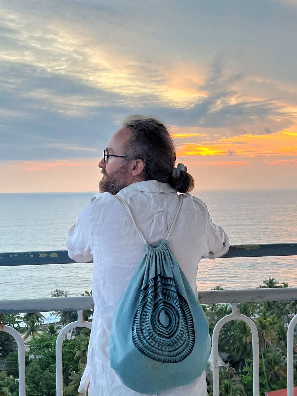 Thibaut de dos, face à la mer, au coucher du soleil